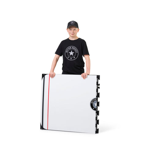 Young hockey player holding a Game Changer training board in a gym setting