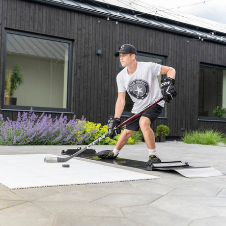 Hockey player using a slide board to train skating stride mechanics and hip mobility outdoors