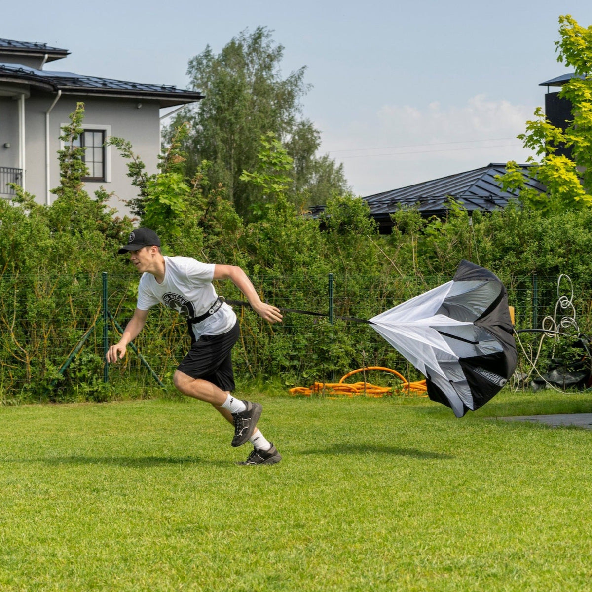 Hockey player running with a speed chute during off-ice conditioning training outdoors
