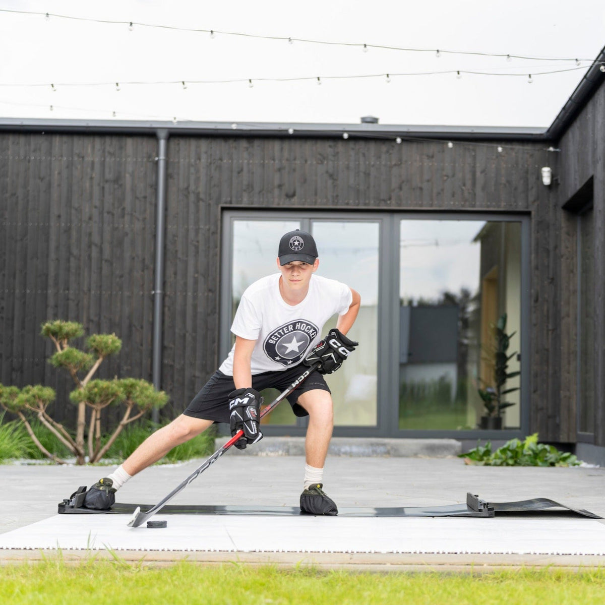 Hockey player training on the Extreme Hockey Slide Board in a backyard — lateral push pattern mirrors skating stride for balance and conditioning